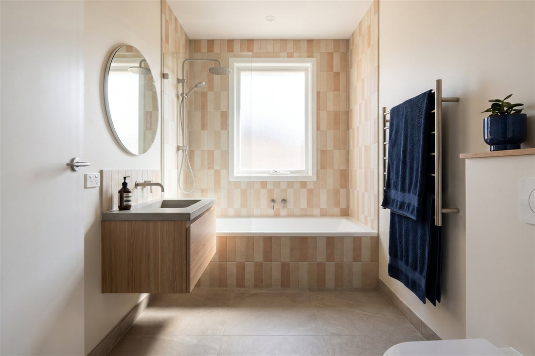 Renovated compact Australian bathroom with a shower-over-bath and floor-to-ceiling tiles
