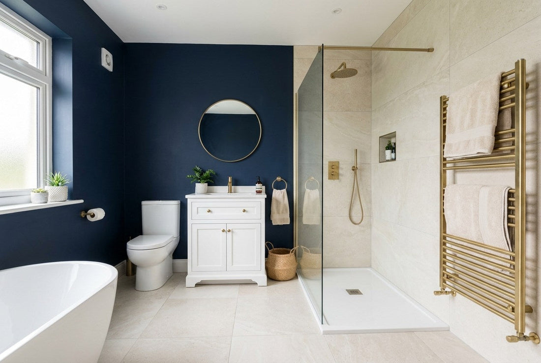 Fully renovated bathroom in an Irish home with navy feature wall, brass tapware, walk-in shower and pale stone tiles