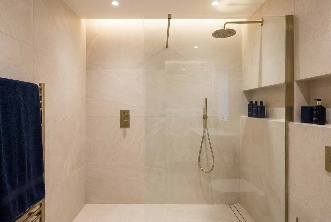 Renovated UK walk-in shower with large-format tiles and brass fittings
