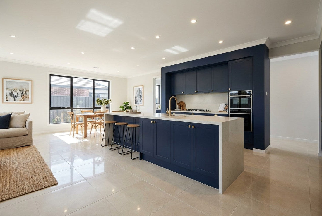 Freshly tiled large-format porcelain floor in a finished Australian open-plan kitchen with navy cabinetry and brass tapware