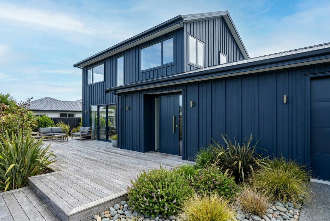 Finished modern New Zealand home exterior with navy board-and-batten cladding and timber deck