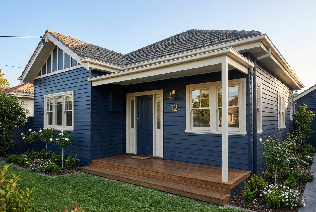 Freshly repainted Australian weatherboard home with deep navy cladding, cream trim and fascia, brass house number and a timber verandah