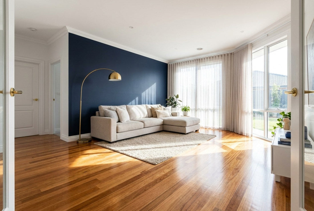Australian living room with freshly sanded and polished solid hardwood timber floorboards, navy feature wall and brass floor lamp