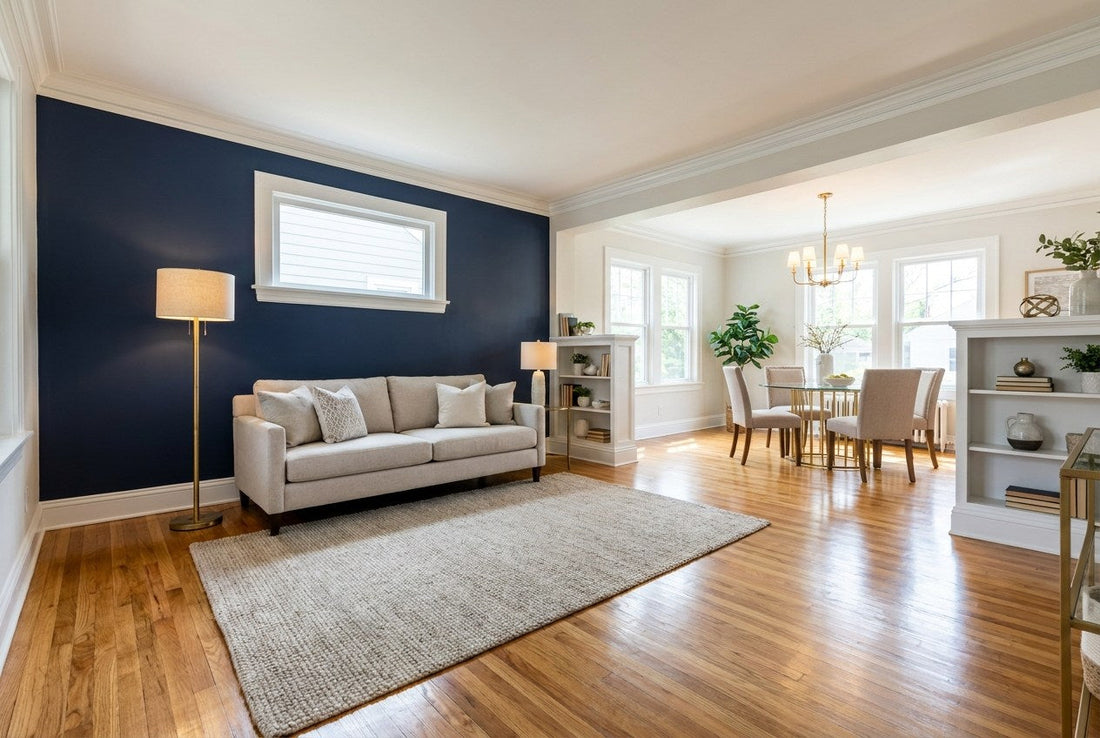 Finished American living and dining room with freshly refinished oak hardwood floors, a deep navy accent wall, white trim, and brass lighting