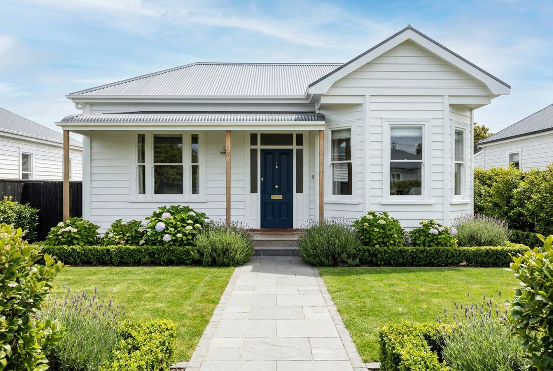 Finished New Zealand weatherboard villa with a navy front door, brass hardware and a tidy garden, the kind of home a Licensed Building Practitioner works on