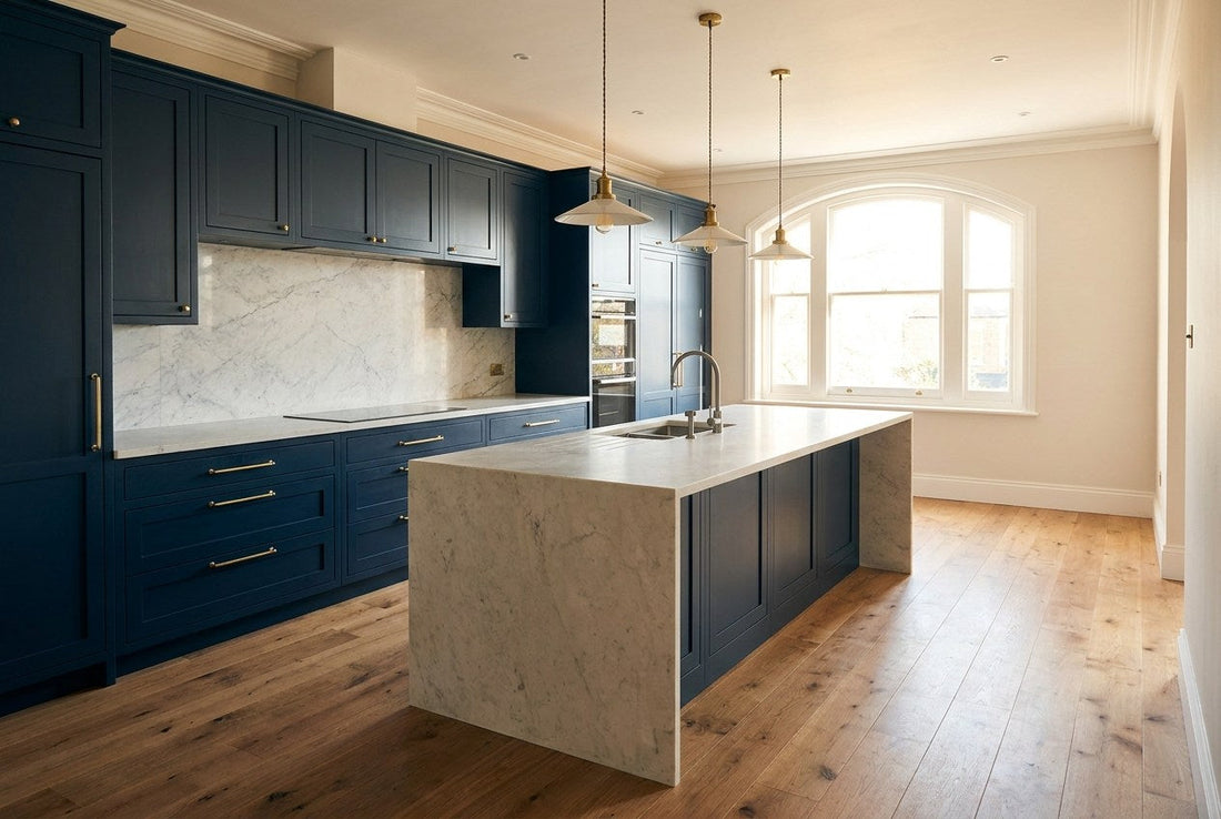 Renovated kitchen with navy cabinetry, brass handles and a pale stone benchtop