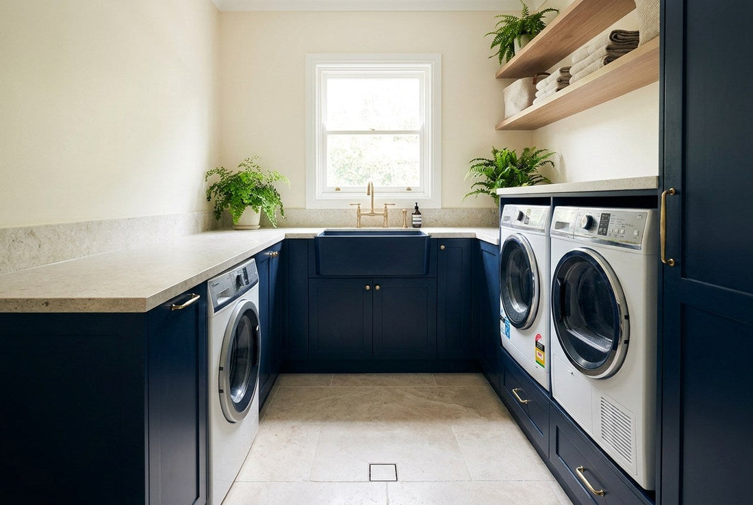 A renovated New Zealand laundry with washing machine and dryer, navy cabinetry and a floor drain