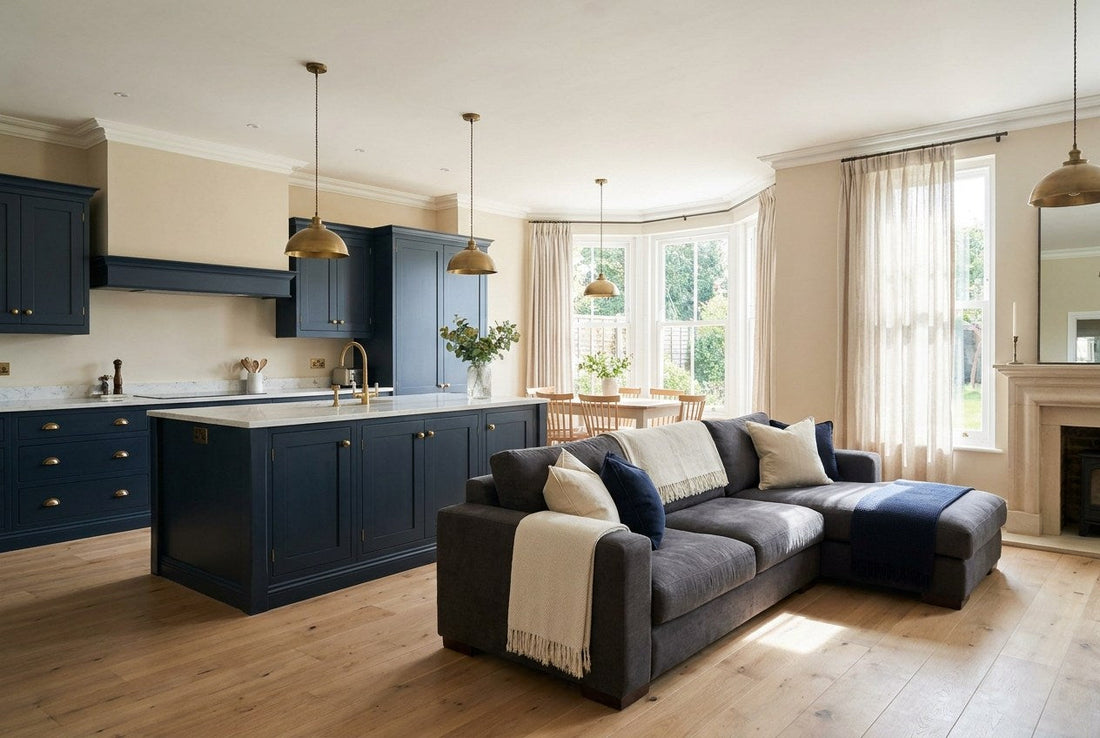 Finished navy open-plan kitchen and living room in a UK home with brushed brass fixtures and light oak flooring