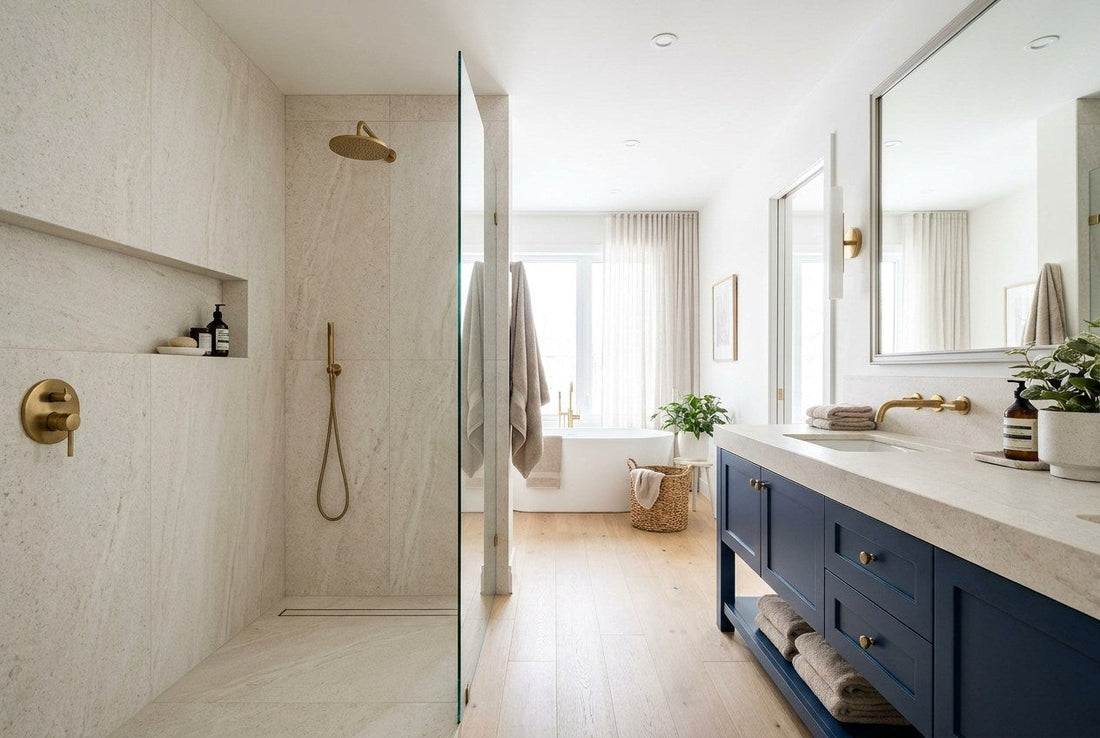 A finished Canadian bathroom with a tiled curbless walk-in shower, frameless glass, brass fixtures, and a navy vanity
