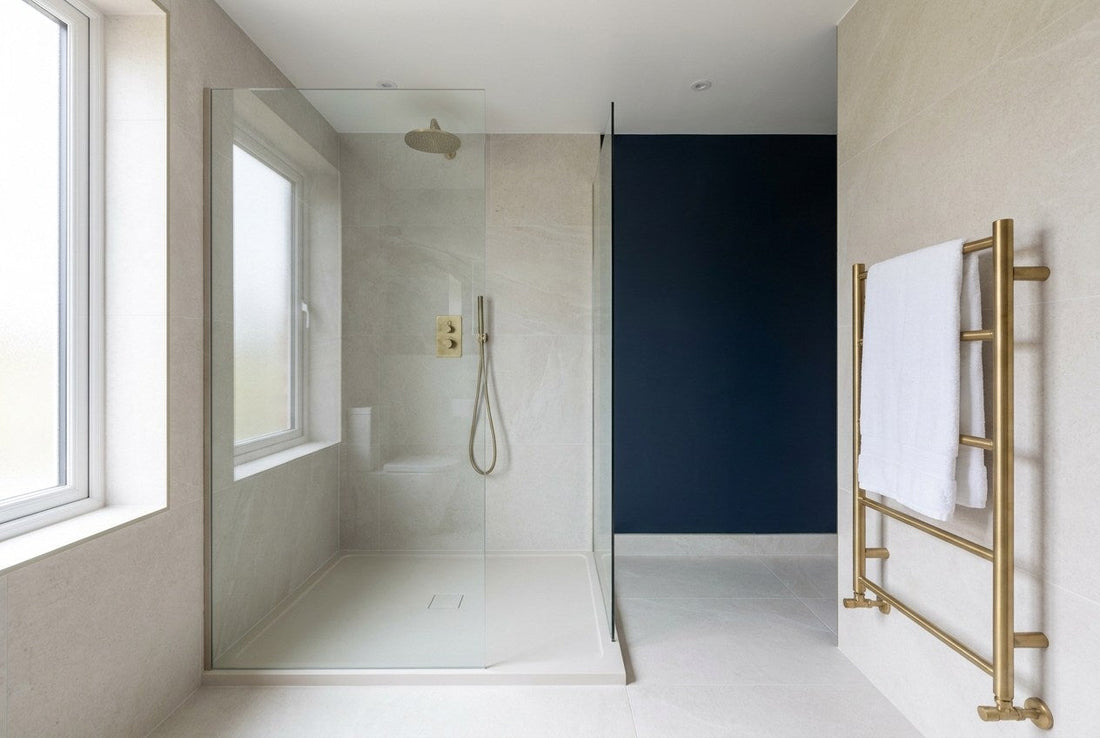 Finished walk-in shower with a low-profile tray and frameless glass screen in a completed UK bathroom