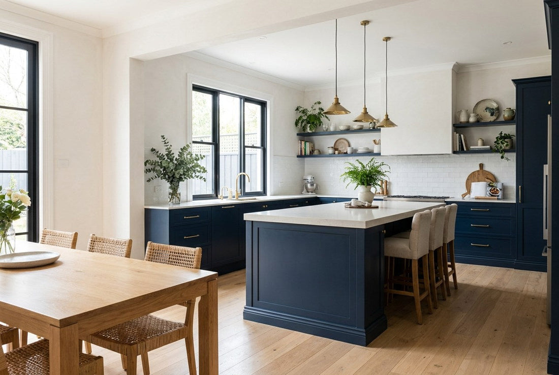 Finished Australian navy shaker kitchen and dining area with brass tapware, a pale stone island benchtop and oak flooring after a full renovation